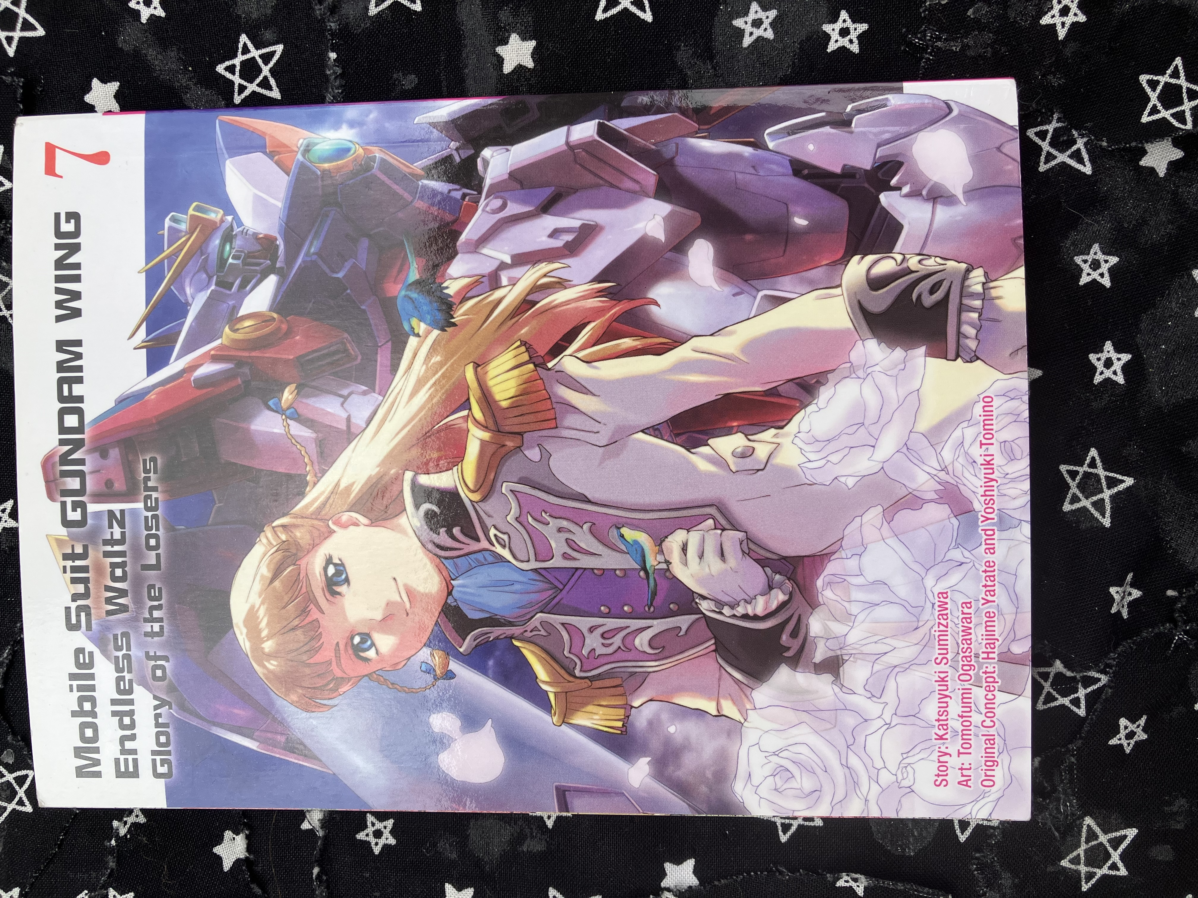 Front of Mobile Suit Gundam WING 7: Glory of the Losers with Relena in her Sanc uniform with white roses in front of her and wing zero behind her.